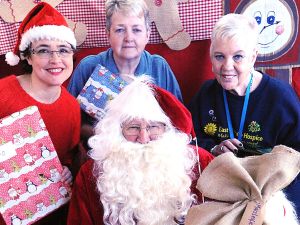 Santa with, from left, grotto organiser Sam Hatton, set designer Sue Pine and East Cheshire Hospice volunteer Midge Barber